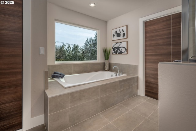 bathroom with tile patterned flooring and tiled tub