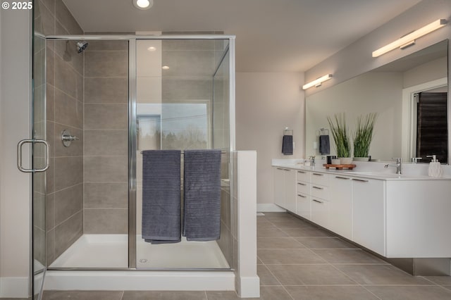 bathroom featuring a shower with door, vanity, and tile patterned floors