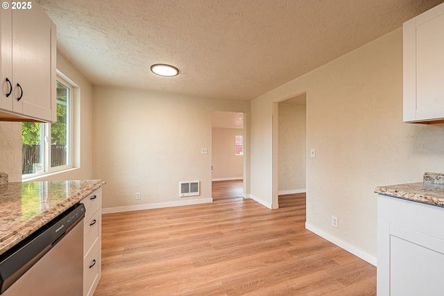 823 20th St, Springfield, OR 97477 - kitchen with stainless steel dishwasher, light wood-style floors, white cabinetry, a textured ceiling, and light stone counters