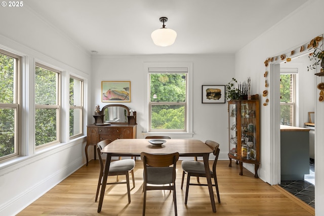1529 SE Hawthorne Blvd Unit 204, Portland, OR 97214 - dining area with baseboards, light wood finished floors, and crown molding
