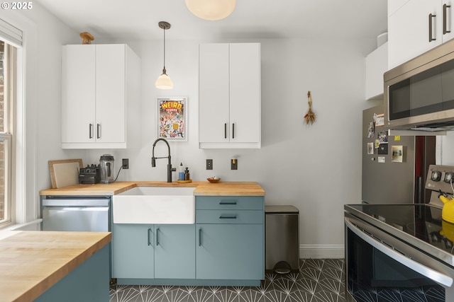 1529 SE Hawthorne Blvd Unit 204, Portland, OR 97214 - kitchen with wood counters, appliances with stainless steel finishes, pendant lighting, and a sink