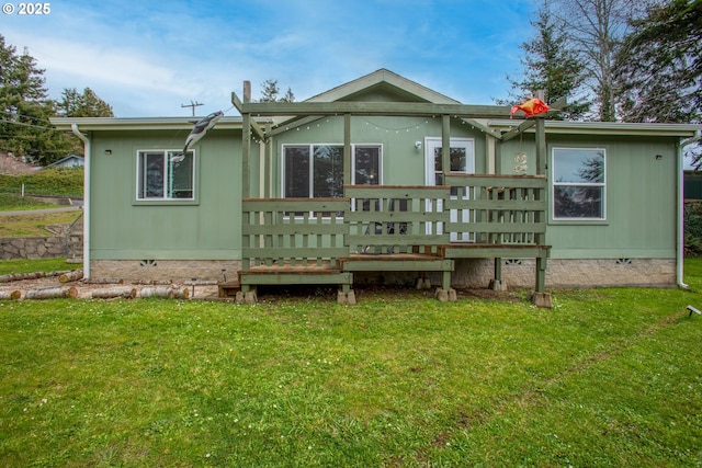 rear view of property featuring a deck and a yard