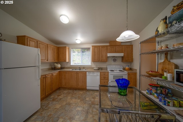 kitchen featuring pendant lighting, stone finish floor, a sink, white appliances, and light countertops