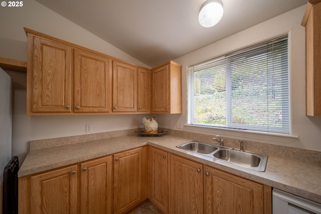 kitchen with white dishwasher, light countertops, lofted ceiling, and a sink