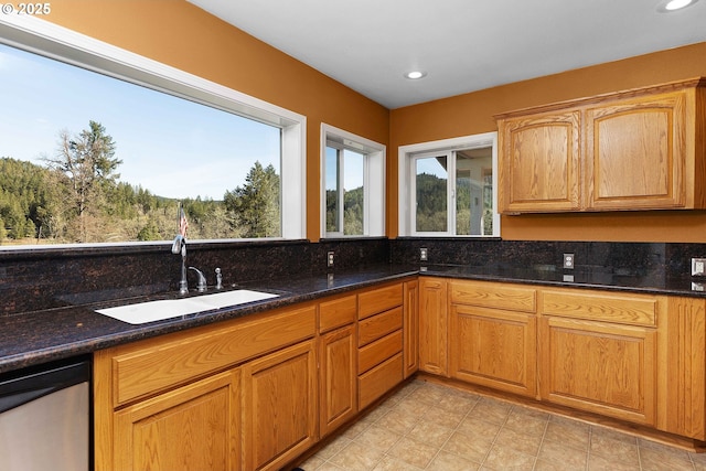 kitchen with dishwasher, dark stone countertops, recessed lighting, and a sink