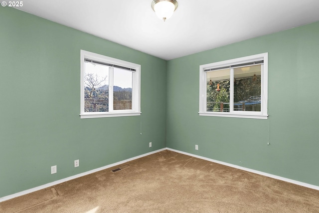 carpeted spare room with baseboards and visible vents