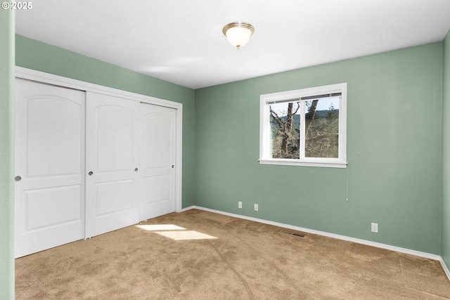 unfurnished bedroom featuring a closet, visible vents, carpet flooring, and baseboards