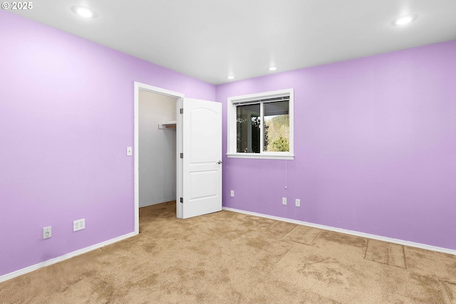 unfurnished bedroom with recessed lighting, a closet, baseboards, and carpet