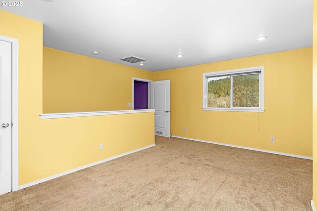 carpeted spare room with visible vents, recessed lighting, and baseboards