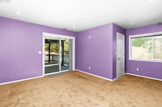 carpeted spare room featuring recessed lighting, visible vents, and baseboards