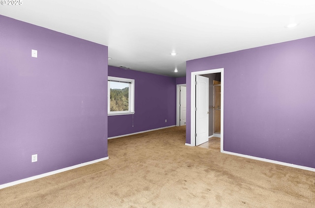 spare room with baseboards and carpet floors