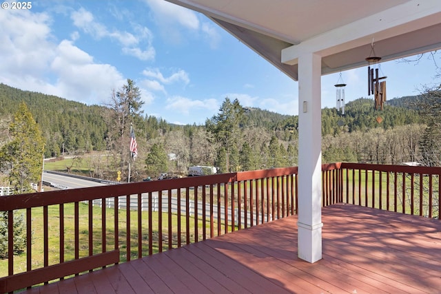 wooden terrace featuring a view of trees