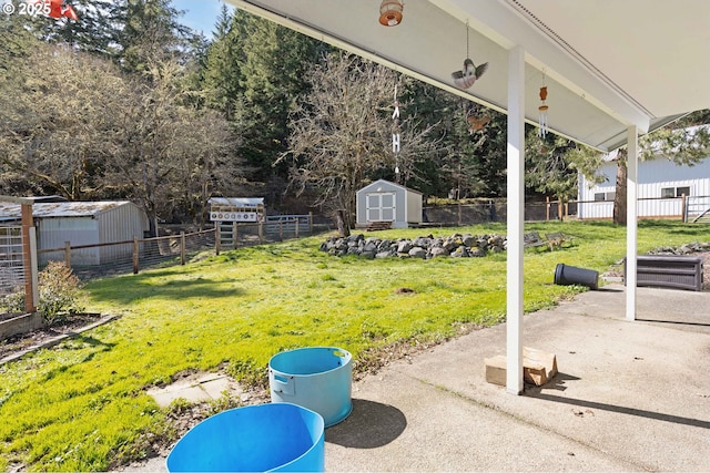 view of yard with a patio, a storage shed, an outdoor structure, and fence