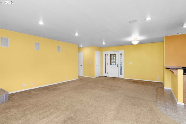 empty room with recessed lighting, light colored carpet, and baseboards