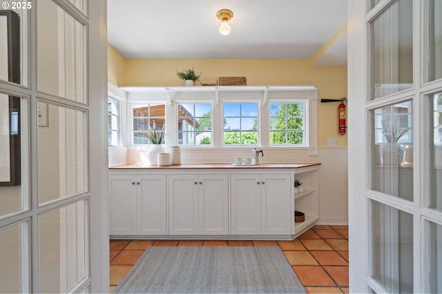 1905 N Sumner St, Portland, OR 97217 - kitchen with light tile patterned floors, a wainscoted wall, and open shelves
