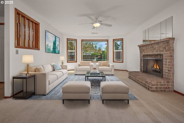 living room with a fireplace, carpet, baseboards, and a ceiling fan