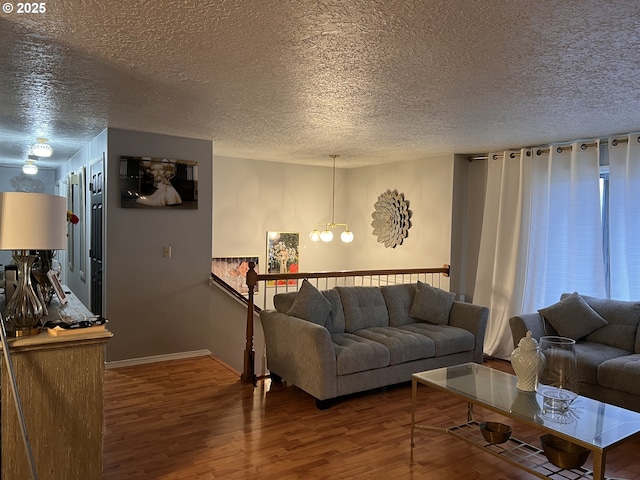 bedroom featuring wood finished floors, baseboards, and a textured ceiling