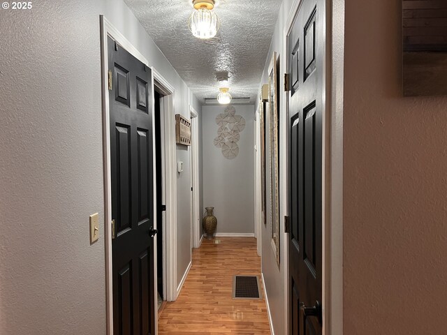 unfurnished bedroom with wood finished floors, a closet, and a textured ceiling