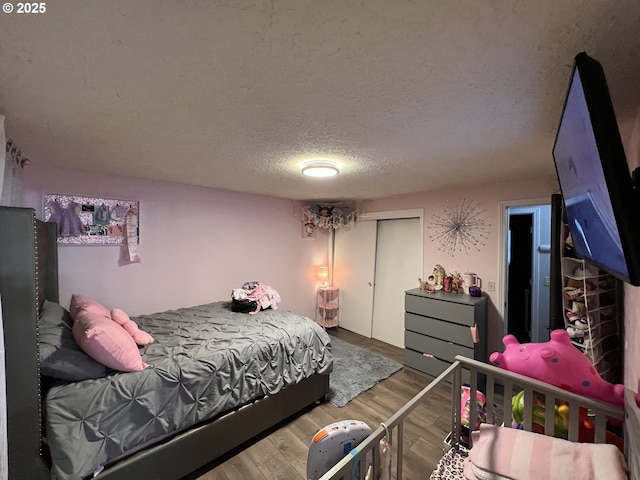 bedroom with a textured ceiling and wood finished floors