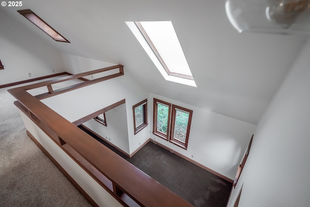 staircase with carpet and vaulted ceiling with skylight