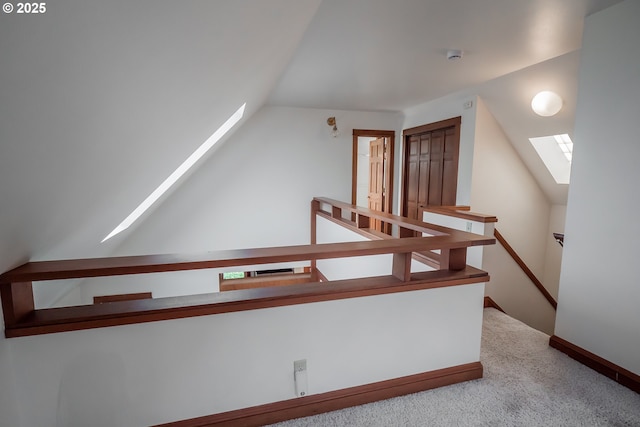 interior space with lofted ceiling with skylight and carpet floors