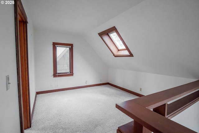 bonus room with light colored carpet and lofted ceiling with skylight