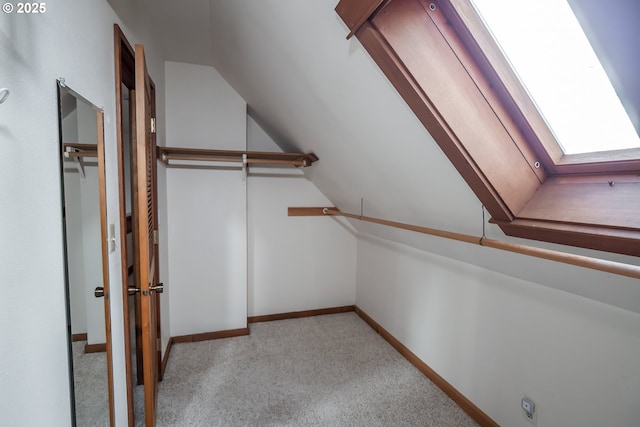 spacious closet with lofted ceiling and light carpet