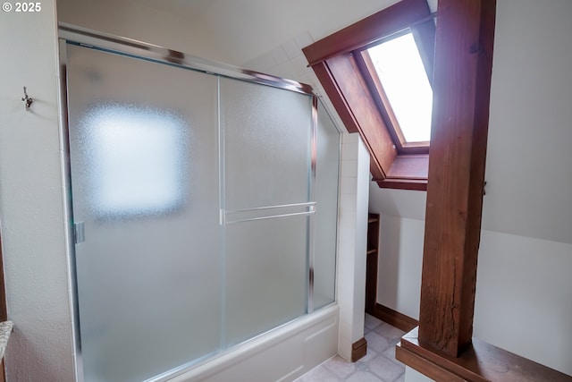 bathroom featuring bath / shower combo with glass door and lofted ceiling with skylight