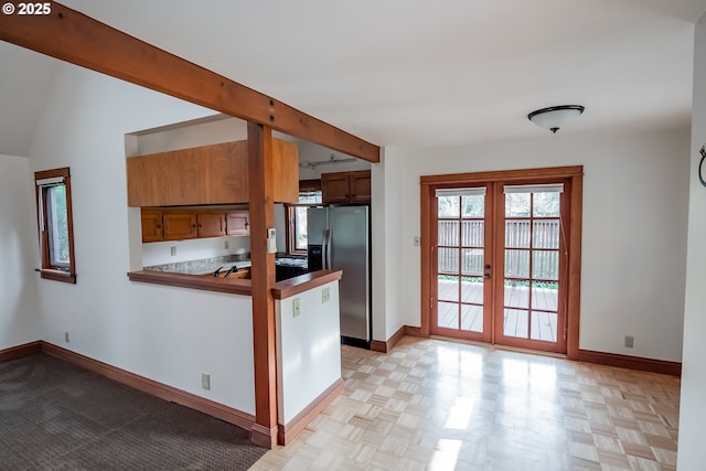 kitchen featuring kitchen peninsula, stainless steel refrigerator with ice dispenser, light parquet flooring, french doors, and beamed ceiling