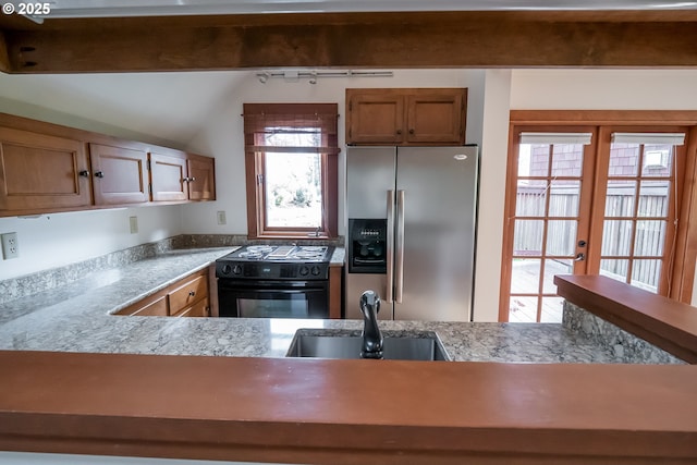 kitchen featuring stainless steel fridge with ice dispenser, french doors, vaulted ceiling, black range with electric stovetop, and sink