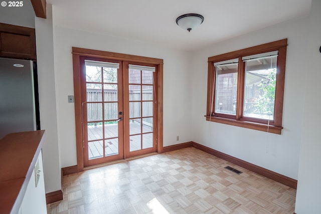 doorway with light parquet floors and french doors