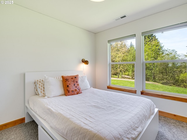 carpeted bedroom featuring visible vents and baseboards