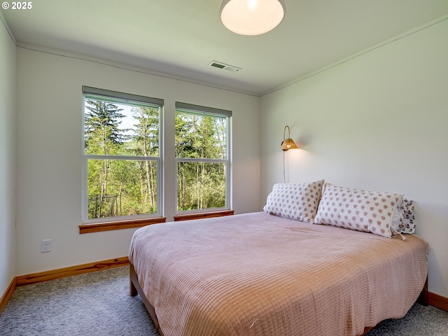 carpeted bedroom featuring baseboards, visible vents, and multiple windows