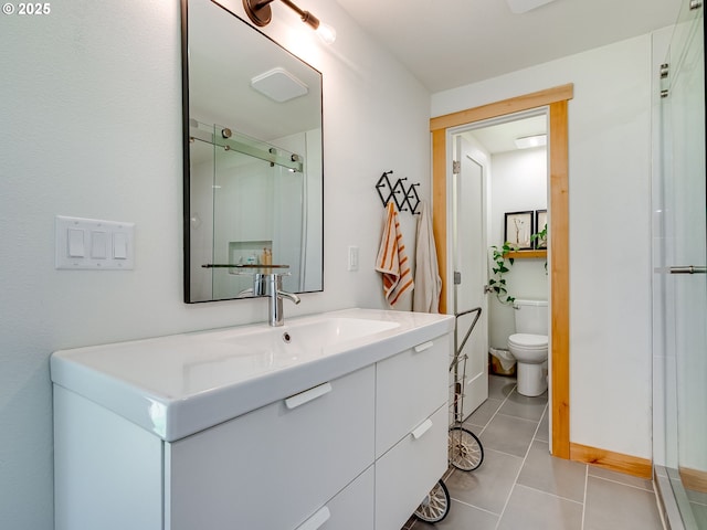 full bath with tile patterned floors, baseboards, vanity, toilet, and a shower with door