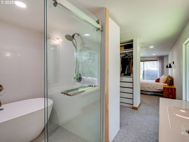ensuite bathroom featuring a sink, recessed lighting, ensuite bathroom, a soaking tub, and a stall shower