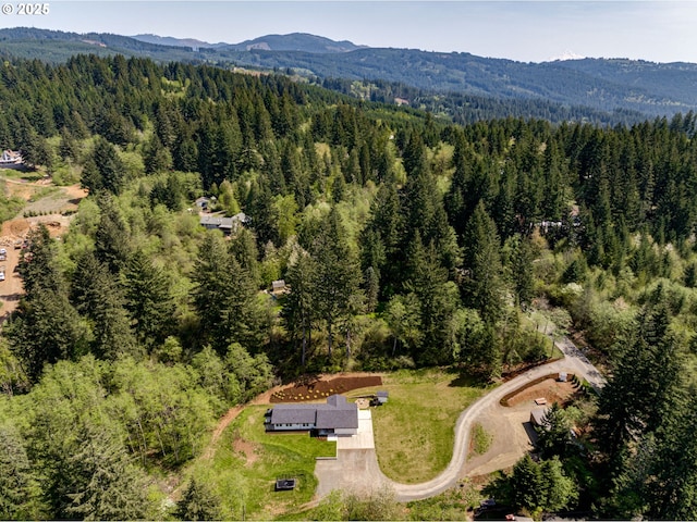 birds eye view of property with a mountain view and a wooded view