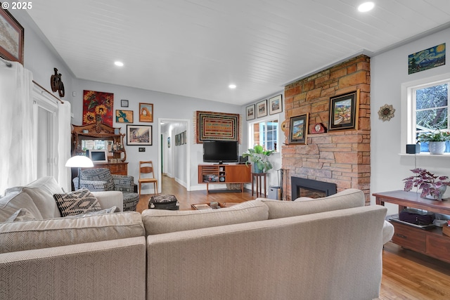 living area with plenty of natural light, a fireplace, light wood-style flooring, and recessed lighting