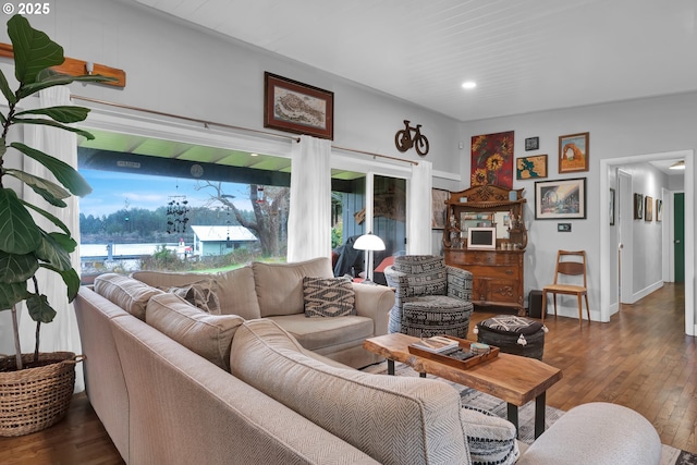 living area with baseboards, wood-type flooring, and a healthy amount of sunlight