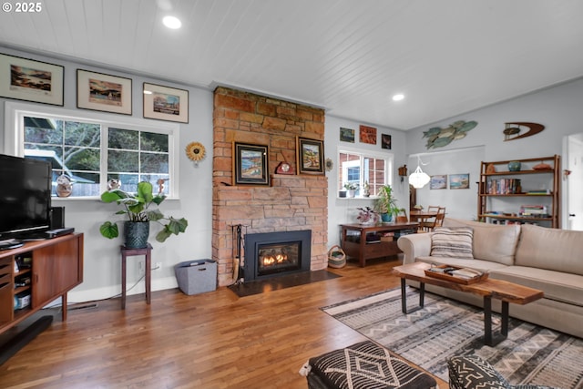 living area with lofted ceiling, recessed lighting, a fireplace, wood finished floors, and baseboards