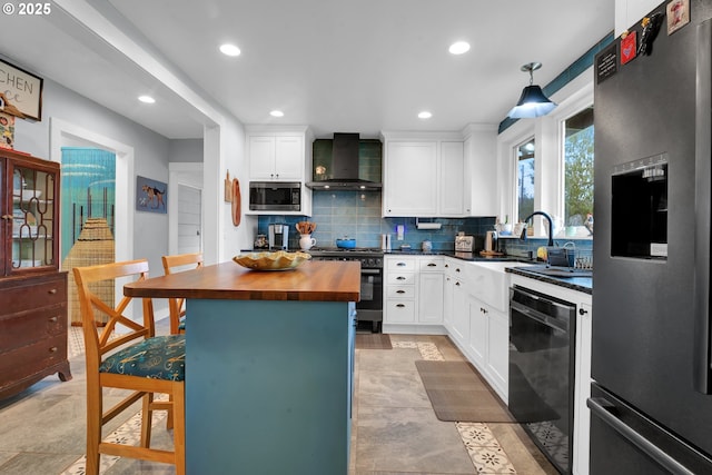 kitchen featuring stainless steel appliances, backsplash, white cabinets, wood counters, and wall chimney exhaust hood