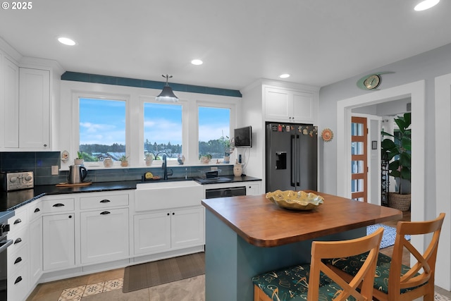 kitchen with recessed lighting, high end refrigerator, a sink, white cabinetry, and backsplash