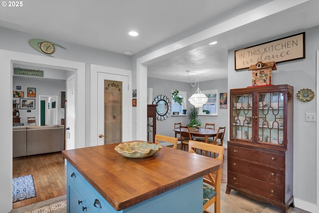 kitchen featuring a notable chandelier, blue cabinetry, recessed lighting, hanging light fixtures, and butcher block countertops