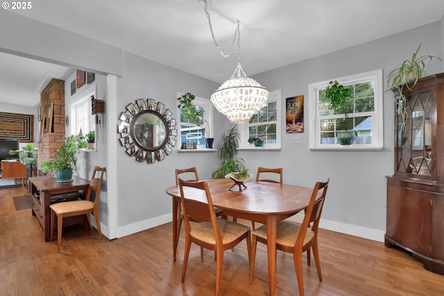 dining area with an inviting chandelier, baseboards, and wood finished floors