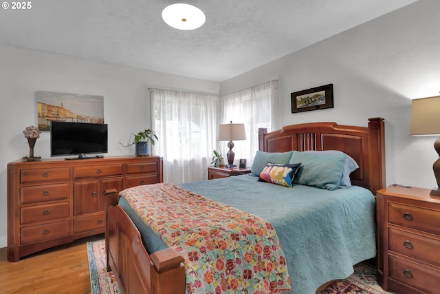 bedroom with light wood-style flooring and a textured ceiling