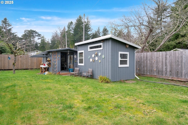 view of outdoor structure with a fenced backyard and an outbuilding