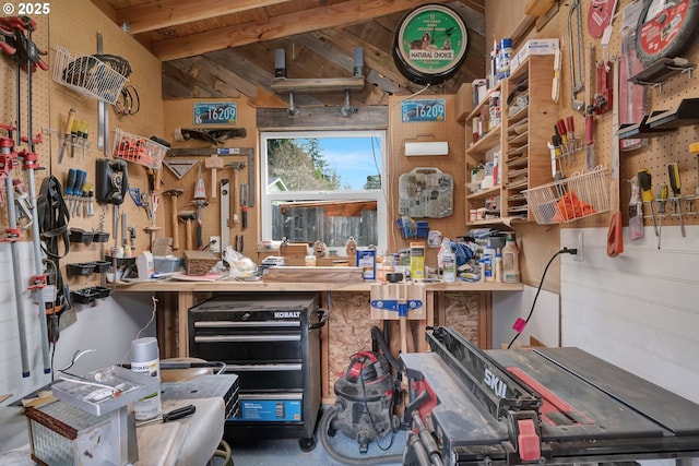 miscellaneous room featuring a workshop area and beam ceiling