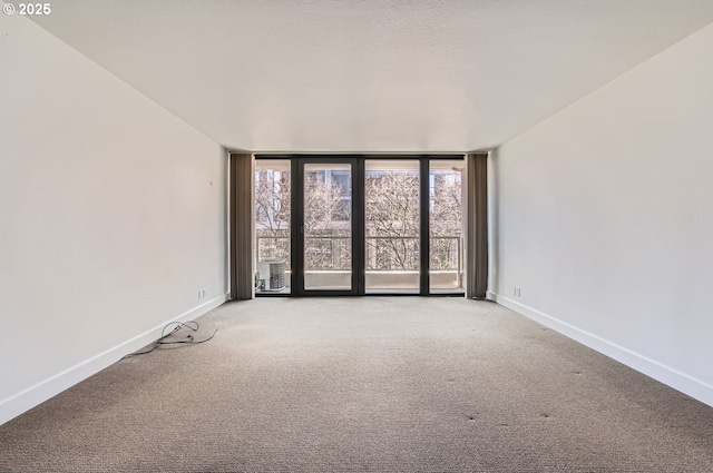 255 SW Harrison St Unit 3C, Portland, OR 97201 - unfurnished room with baseboards, light colored carpet, and expansive windows