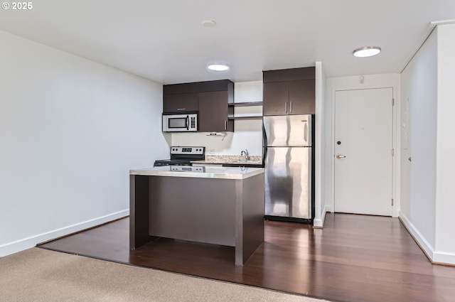 255 SW Harrison St Unit 3C, Portland, OR 97201 - kitchen with appliances with stainless steel finishes, a sink, light countertops, and dark wood-type flooring