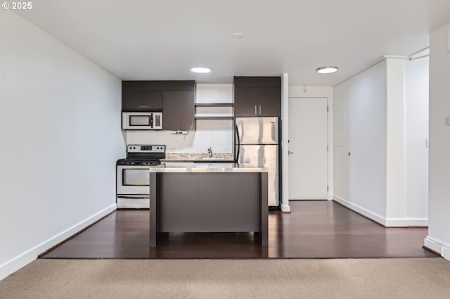 255 SW Harrison St Unit 3C, Portland, OR 97201 - kitchen featuring stainless steel appliances, a center island, baseboards, light countertops, and a sink