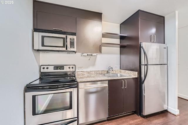 255 SW Harrison St Unit 3C, Portland, OR 97201 - kitchen featuring stainless steel appliances, a sink, open shelves, dark wood finished floors, and light countertops